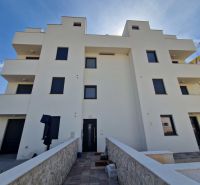 The exterior of a building with a 3-room apartment in Povljana with sunny weather.