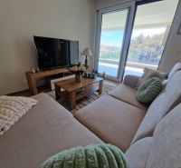 Living room in a 3-room apartment with a large sofa and a television.