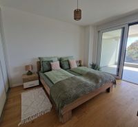 A bedroom in light tones with a wood-patterned floor in a 3-room apartment.