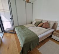 A bedroom with light furniture and a wooden decor floor in a 3-room apartment.