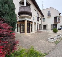 Commercial premises on Práce in Komárno with greenery and parking spaces.
