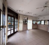 Interior of commercial premises with tiles, mirrors, and a sink.