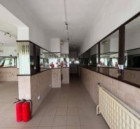 Commercial premises with tiled flooring and a mirrored wall, fire extinguishers, built-in lighting.