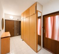 Entrance hall in a 3-room apartment with wooden doors and wardrobes, tiled floor.