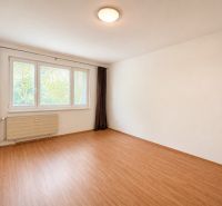 A spacious room with a wooden decor floor in a 3-room apartment.