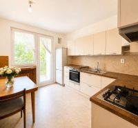 A kitchen in a 3-room apartment with a gas stove and a wooden table.