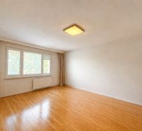 A spacious room with a wood-patterned floor in a 3-room apartment, neutral walls.