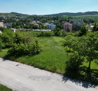 A residential plot in Myjava, surrounded by green trees and a view of the city.