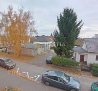 Autumn view of the street in Senica, showing trees and parked cars in front of a 3-room apartment.