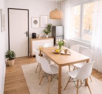 A designer dining room with wood-patterned flooring and stylish furniture in a 3-room apartment.