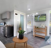Interior of a family house with a wooden decor floor, kitchen, and living room.