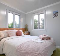 A bright bedroom in a family house with pink decorative elements and wooden floor decor.