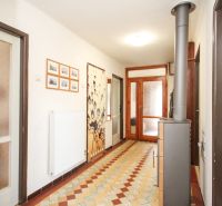 A hallway in a family house with tiles, decoration, and a radiator on the wall.