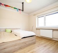 A bedroom in a family house with a bed and a wooden decor floor.