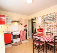 A kitchen in a family house with wooden decor and red equipment.