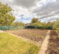 The garden of a family house with well-maintained grass and a flower bed in Trenčín on Niva Street.