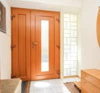 Family house with wooden doors and tiles, glass blocks on the sides.