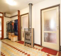 A hallway with a fireplace stove and colorful tiles in a family house.