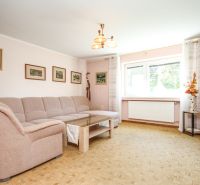 Living room in a family house with a corner sofa and a wooden decor floor.