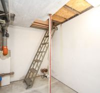 The staircase leads to the attic in a family house, visible are the water and waste pipes.