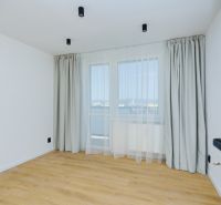 An empty room in a 4-room apartment with white walls and a wooden-patterned floor.