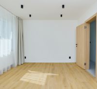 A room in a 4-room apartment with a wood-patterned floor and curtains.