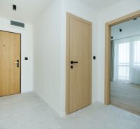 A bright hallway with light doors and a wooden decor floor in a 4-room apartment.