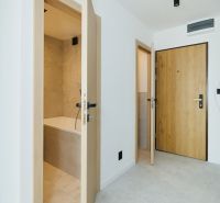 The hallway of a 4-room apartment with white walls, doors, and a bathroom.