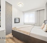 Bedroom in a family house with a bed, television, and wardrobe, floor with wooden decor.