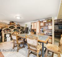 A dining room in a family house with a dining table, wooden chairs, and a burgundy wall.