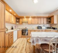 A kitchen with wooden decor and a large dining table in a family house.