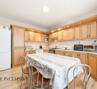 A kitchen in a family house with a kitchen unit, table, and floor with a wooden decor.