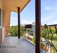 A balcony of a family house in Gabčíkovo with floral decorations and a view of the surroundings.