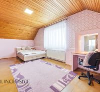 Attic room in a family house with a wooden decor floor and pink walls.
