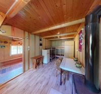 Wooden interior of a cabin with a wood-patterned floor and a table with decorations.