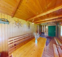 Interior of a cabin with wooden benches, a table, and decorations, floor with wooden decor.