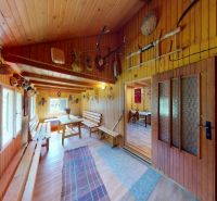 Interior of a cabin with wooden paneling, benches, and decorations.