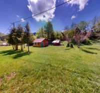 A cottage near Poráč surrounded by a green meadow and trees, an ideal place for relaxation.