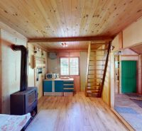 Interior of a cottage with a stove and a wooden decor floor.