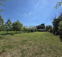 A spacious green plot in Potônske Lúky surrounded by trees, ideal for living.