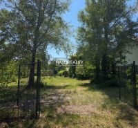 Land - residential in Potônské Lúky, fenced area with lawn and trees.