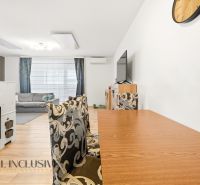 A dining room with a wooden decor floor and stylish chairs in a 3-room apartment.