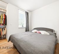Bedroom in a 3-room apartment with storage space and a bed, floor with wooden decor.