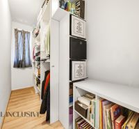Storage space in a 3-room apartment with shelves and flooring with a wood decor.