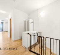 A hallway in a 3-room apartment with white furniture and a wooden decor floor.