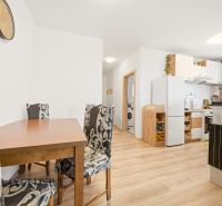 Kitchen and dining area in a 3-room apartment with a wooden decor floor.