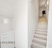 A hallway in a 3-room apartment with storage space and a staircase.