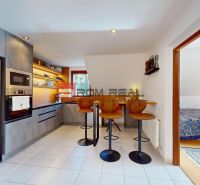 A kitchen in a family house with bar seating and modern appliances.
