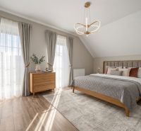 A bedroom with wood-patterned flooring, stylish curtains, and modern lighting in a family house.