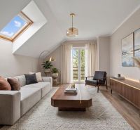 Elegant living room of a family house with a skylight, large sofa, and decorative plants.